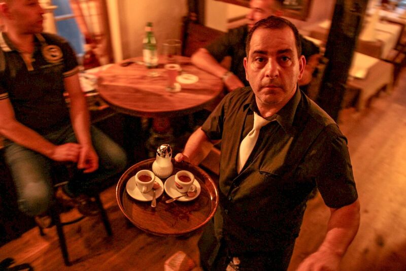 Mitarbeiter mit Espressotassen im Gastraum
